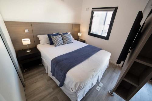 1 dormitorio con 1 cama grande con almohadas azules y blancas en Aventura 208 en Buenos Aires