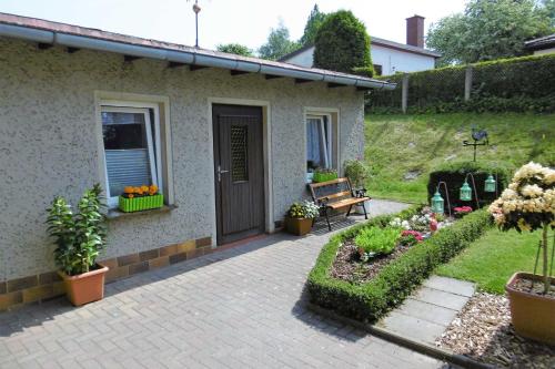 una casa con un porche con un banco y flores en Ruegen_Fewo 144, en Bergen auf Rügen