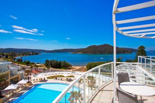 a balcony with a pool and a view of the water at Ettalong Beach Luxury Apartments in Ettalong Beach