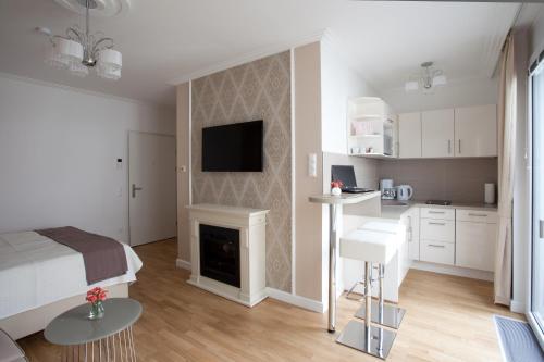a bedroom with a bed and a kitchen with a fireplace at Sofie Apartments in Vienna