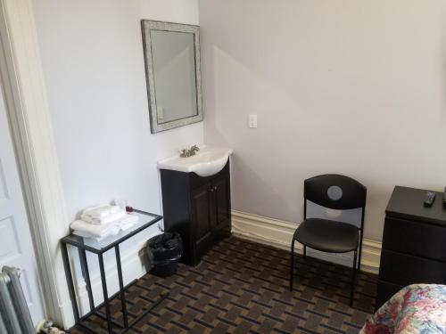 a bathroom with a sink and a mirror and a chair at Perramont Hotel in San Francisco