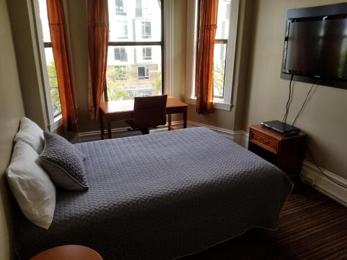 a bedroom with a bed and a flat screen tv at Perramont Hotel in San Francisco