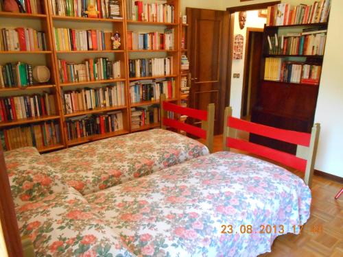 a bedroom with two beds in front of book shelves at B&B La Pilastrina in Maranello