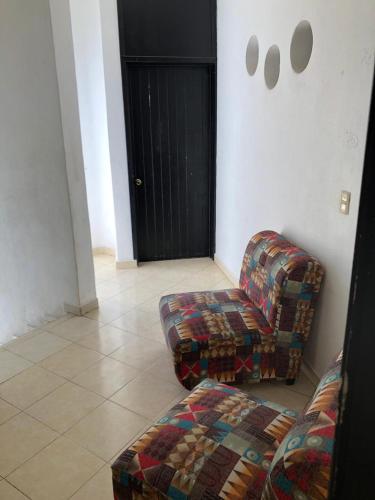 a living room with a couch and a chair at Casa y Villa Diamante, Manzanillo in Manzanillo