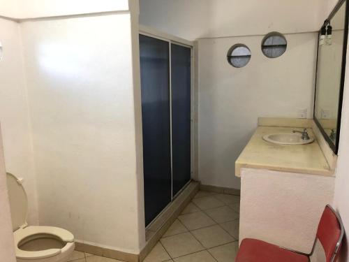 a bathroom with a toilet and a sink at Casa y Villa Diamante, Manzanillo in Manzanillo