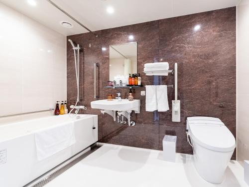 a bathroom with a white toilet and a sink at Hiyori Hotel Osaka Namba Station in Osaka