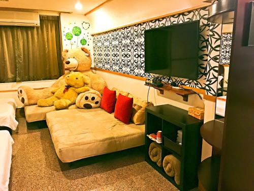 a room with a large teddy bear sitting on a couch at Hello B&B in Tainan