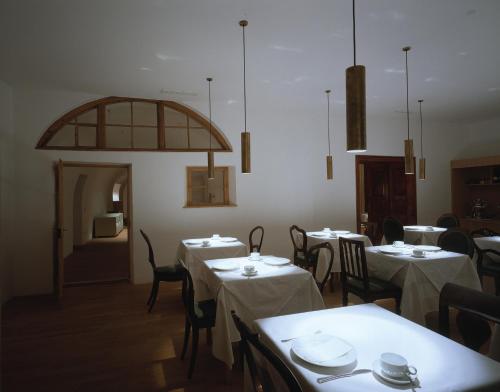 a dining room with tables and chairs with white table cloth at Hotel Gasthof Grüner Baum in Glorenza