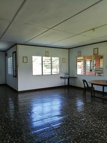 an empty room with a table and two windows at AA Homestay in Mulu