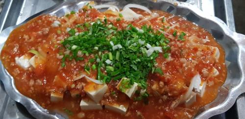 a dish of food with sauce and herbs on it at Garden Homestay in Di Linh