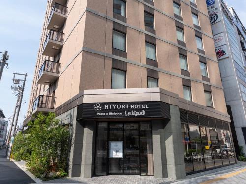 a building with a sign on the front of it at Hiyori Hotel Osaka Namba Station in Osaka