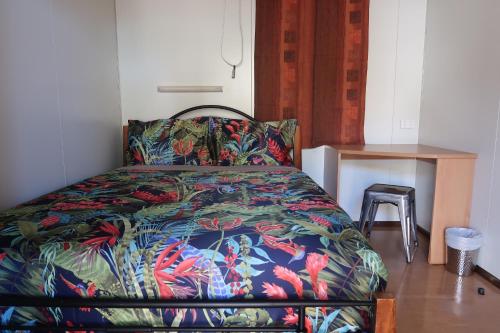 ein Bett mit farbenfroher Bettdecke in einem Schlafzimmer in der Unterkunft Mud Crab Motel in Derby
