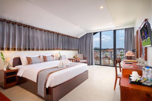 um quarto com uma cama grande e uma varanda em Mony Reach Angkor Hotel em Siem Reap