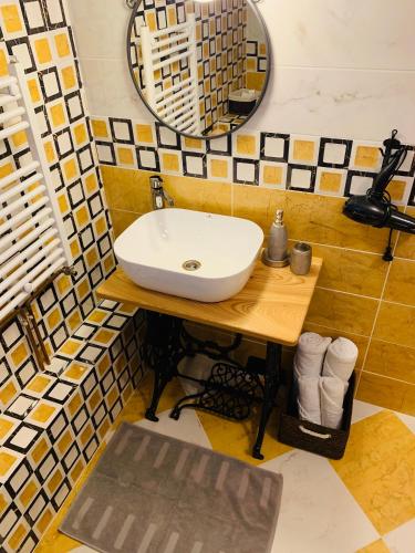 a bathroom with a white sink and a mirror at Casa "La Moara din Grădină" in Eftimie Murgu
