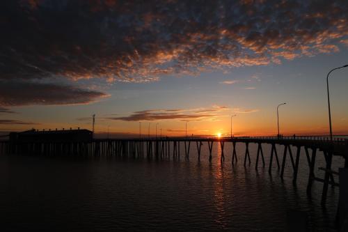 a bridge over the water with the sunset in the background at Mud Crab Motel in Derby