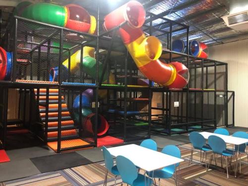 a room with a playground with a slide and tables and chairs at NRMA Mildura Riverside Holiday Park in Mildura