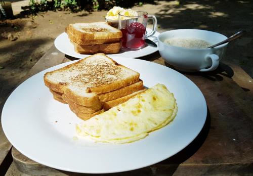 two white plates with toast and a cup of coffee at Breeze Guest House in Trincomalee