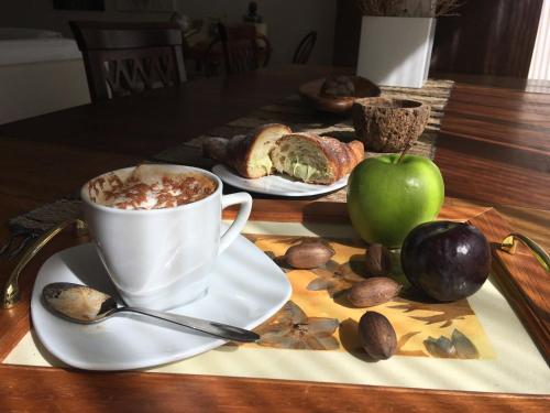 a table with a cup of coffee and a plate of food at Porta del Vento in Giardini Naxos