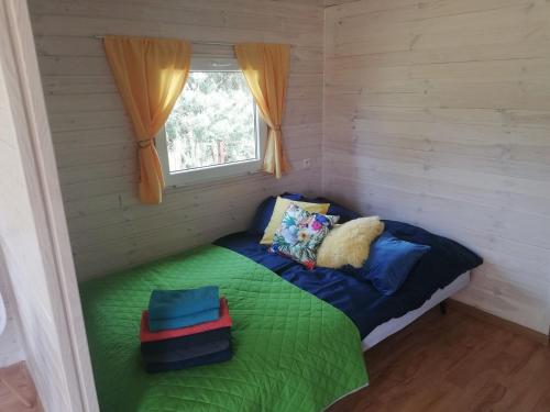a small room with a bed with a window at Miodowy Zakątek Całoroczne Domki i Pokoje przy Suntago, Deepspot, Pyszne Śniadania, Grill in Mszczonów