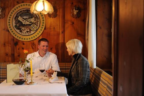 a man and woman sitting at a table in a restaurant at Hotel Post Kappl in Kappl
