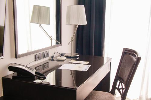 a desk in a hotel room with a phone at 1898 Hotel Colonia En Las Filipinas in Manila