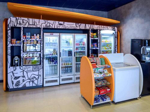 a soda machine in a store next to a refrigerator at ibis budget Sorocaba in Sorocaba