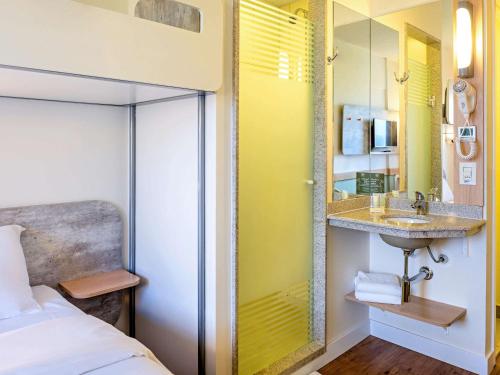 a bedroom with a sink and a mirror at ibis budget Sorocaba in Sorocaba