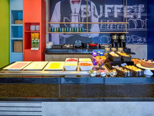 a counter with different types of food on display at ibis budget Sorocaba in Sorocaba