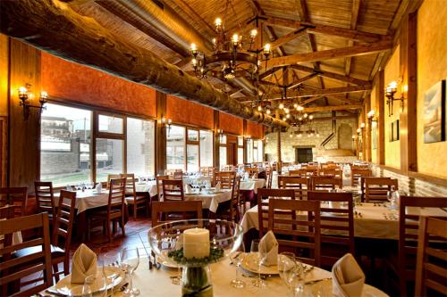 Villa Ferrera Posada Rural في Herrera de Valdecañas: مطعم فيه طاولات وكراسي في الغرفة