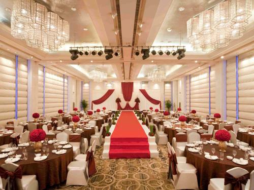 a banquet hall with tables and chairs and a red carpet at Grand Mercure Shanghai Hongqiao in Shanghai