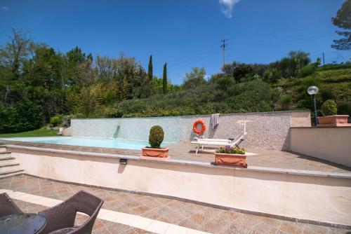 a swimming pool with two chairs and a table at Hotel La Colonna in Siena