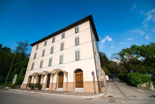 a large white building on the side of a street at Hotel La Colonna in Siena