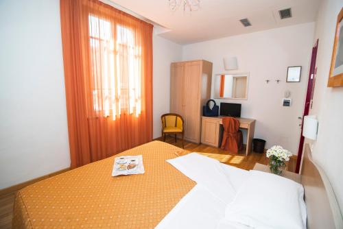 a bedroom with a bed and a room with a desk at Hotel La Colonna in Siena