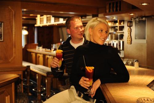 a man and a woman standing at a bar at Hotel Post Kappl in Kappl