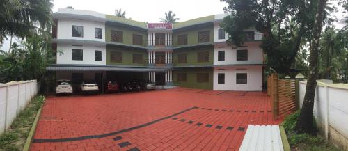 a building with a red brick driveway in front of it at Airavatham Apartments in Guruvāyūr