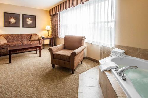 a hotel room with a bath tub and a chair at Comfort Inn & Suites McMinnville Wine Country in McMinnville