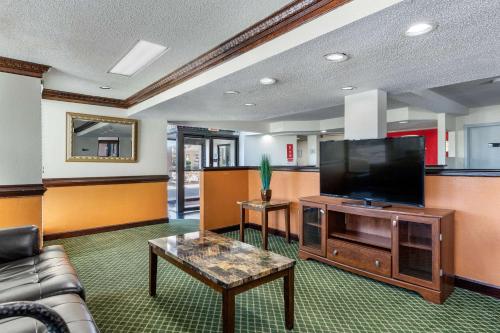 a living room with a flat screen tv and a couch at Econo Lodge Florence - Darlington in Florence