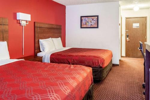 Habitación de hotel con 2 camas y paredes rojas en Econo Lodge, en Prineville