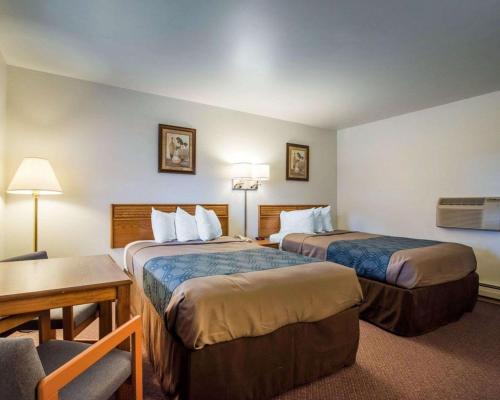 Habitación de hotel con 2 camas y mesa en Econo Lodge, en Saint Albans
