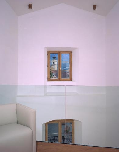 a white room with a white couch and a window at Hotel Gasthof Grüner Baum in Glorenza