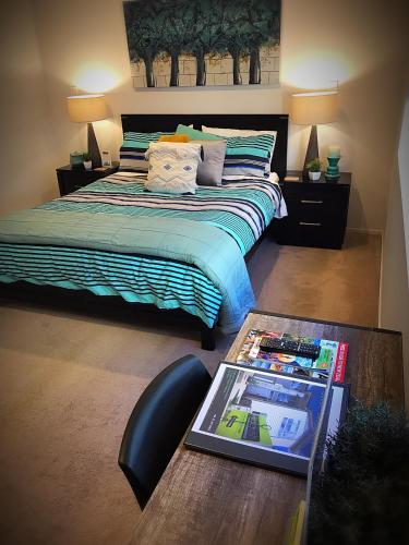 a bedroom with a bed and a desk with a table with a book at Flat Bush Holiday Accomodation in Auckland