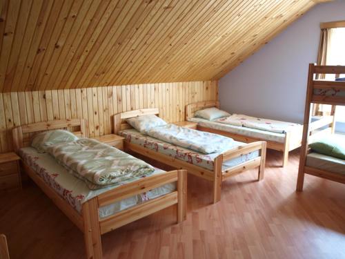 a room with three beds in a cabin at Guest House Kalnu pūpoli in Šengeida