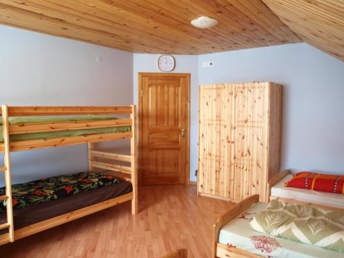 a bedroom with two bunk beds and a door at Guest House Kalnu pūpoli in Šengeida