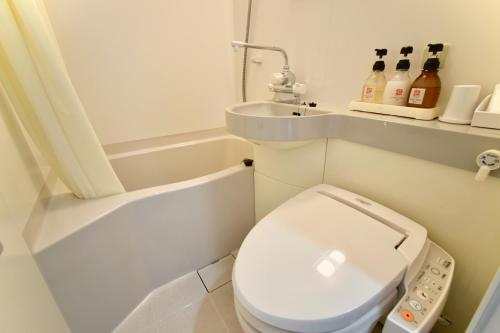 a small bathroom with a toilet and a sink at Hotel Frontier Iwaki in Iwaki