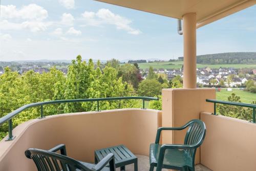 a balcony with chairs and a view at Hotel Hochsauerland by Center Parcs in Medebach