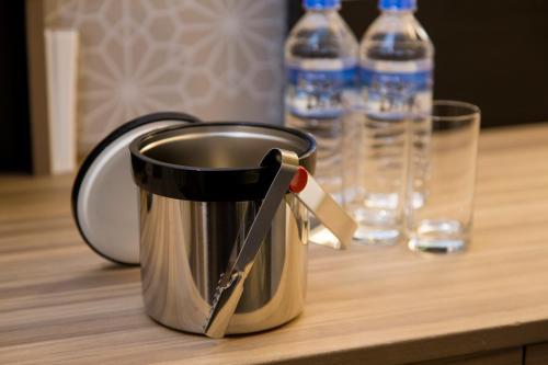 a pot sitting on a table with two water bottles at Hotel Monterey Le Frere Osaka in Osaka