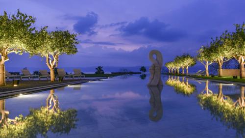 a statue standing in a pool at night at Kempinski Hotel Ishtar Dead Sea in Sowayma
