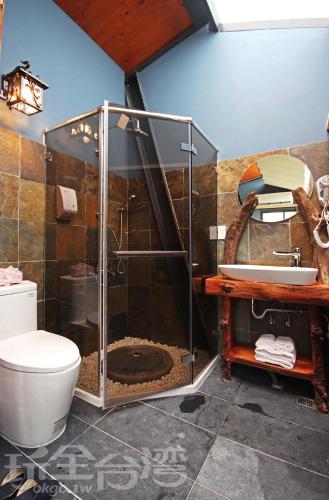 a bathroom with a shower with a toilet and a sink at Yue Lake Backpackers in Yuchi