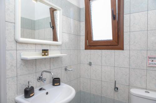 a bathroom with a sink and a mirror and a toilet at Studio Tolakis in Plaka