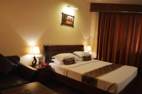 a hotel room with a bed and a couch at Malligi,Hampi in Hospet